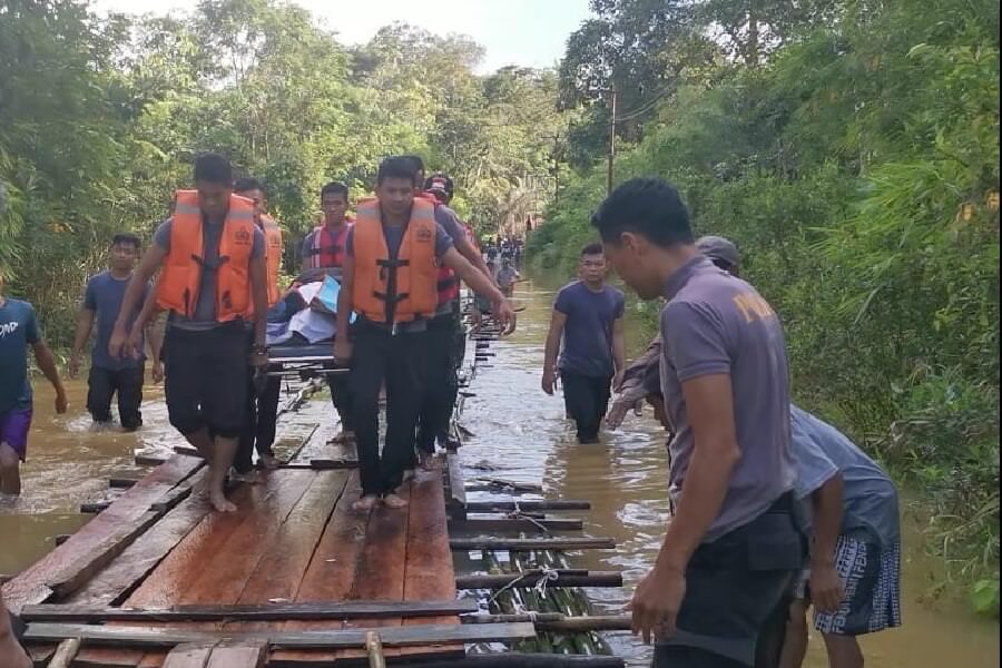 Anggota Polres Landak mengevakuasi jenazah warga Desa Selaba di tengah kepungan banjir, Selasa (10/12). foto ISTIMEWA