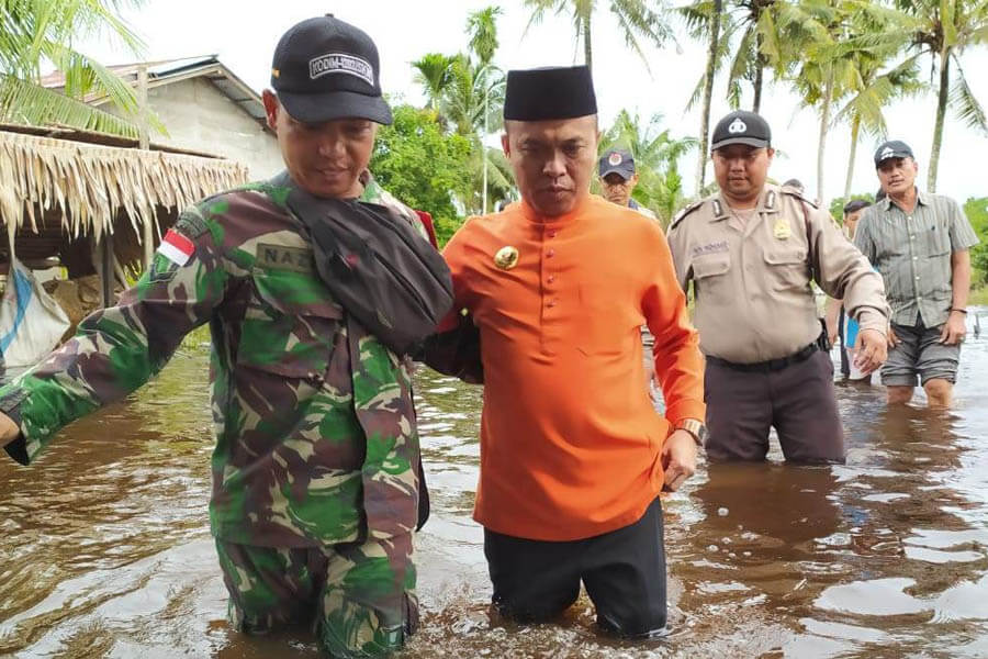 BANJIR: Bupati Sambas, H Atbah Romin Suhaili usai membantu logistik korban banjir di sejumlah wilayah Kecamatan Paloh. Gambar lain, Wabup Sambas Hj Hairiah yang turun melihat sejumlah desa yang terendam banjir.  FAHROZY/PONTIANAKPOST