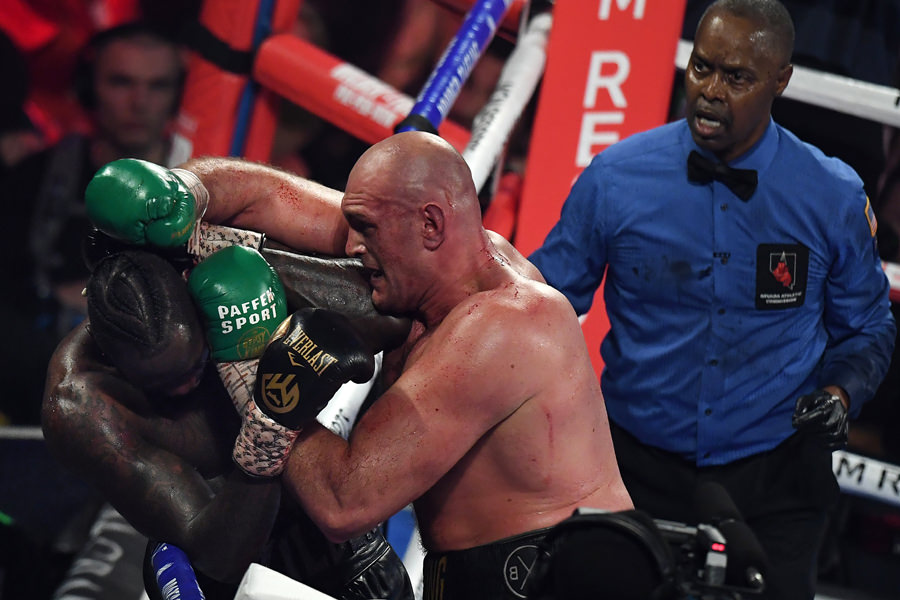 British boxer Tyson Fury (C) lands a punch before defeating US boxer Deontay Wilder in the seventh round during their World Boxing Council (WBC) Heavyweight Championship Title boxing match at the MGM Grand Garden Arena in Las Vegas on February 22, 2020. (