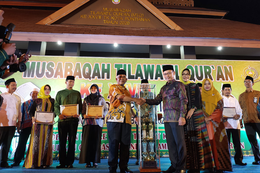 Wali Kota Pontianak, Edi Rusdi Kamtono menyerahkan piala juara umum Musabaqah Tilawatil Quran (MTQ) XXVIII Tingkat Kota Pontianak kepada Camat Pontianak Utara, Kuswandi yang merebut juara umum.