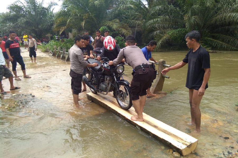 Personel Sat Sabhara Polres Landak bersama warga membangun jembatan darurat di lokasi banjir Dusun Karangan Mas, Desa Pawis Hilir, Kecamatan Jelimpo Landak, Rabu (26/2). Foto Istimewa