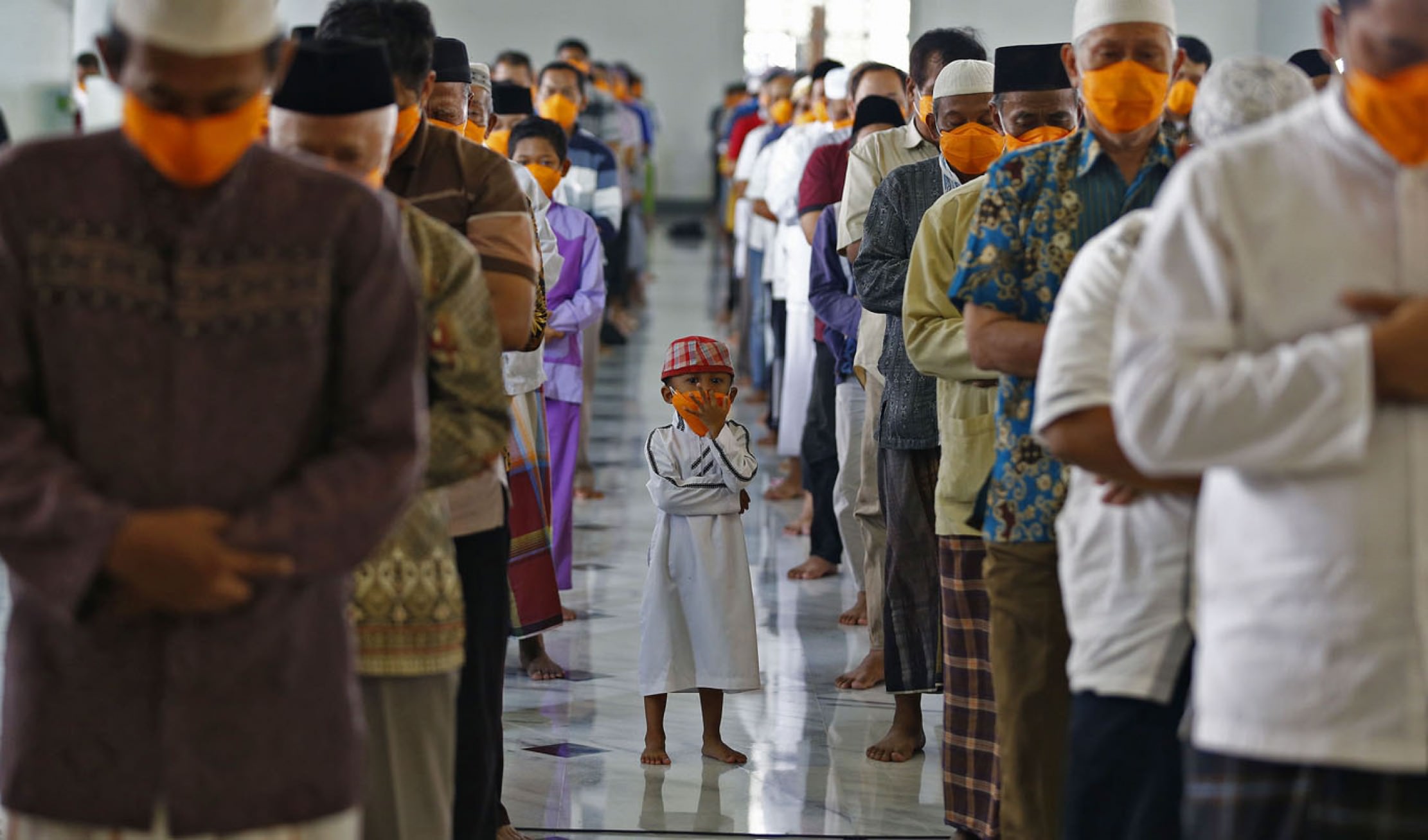Ribuan jemaah Masjid Al-Akbar tetap melaksanakan shalat jumat dengan diberikan masker dan jarak antara jemaah, kemarin, Jumat (20/3/2020).FOTO:Dipta Wahyu/Jawa Pos