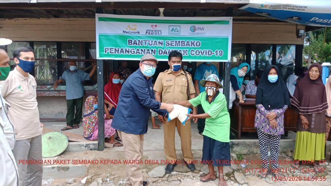 BANTUAN : Artha Graha Peduli Melalui PT. Pasifik Agro Sentosa saat memberikan bantuan bahan pokok bagi masyarakat di Desa Pinang Luar, Kubu Raya.