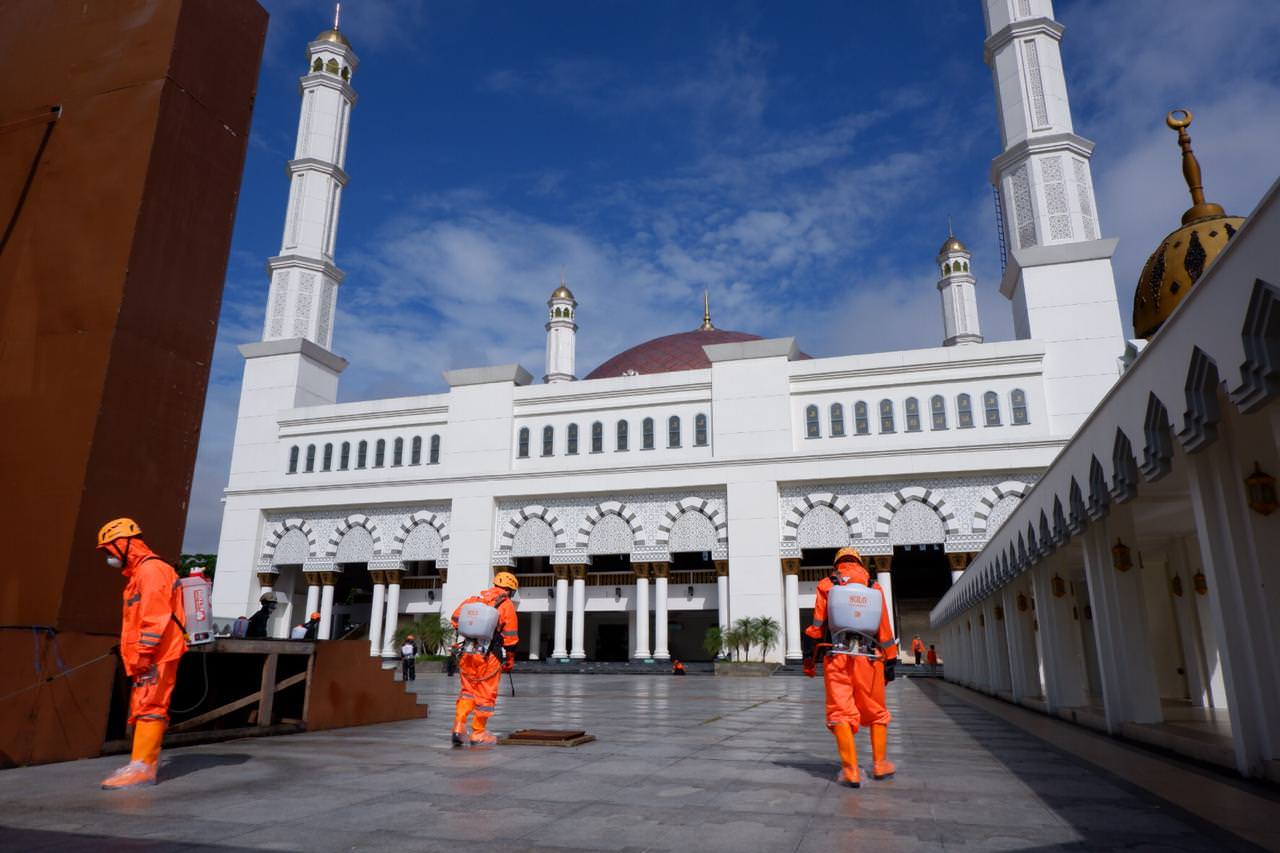 TAK DIGELAR: Sejumlah petugas menyemprotkan disinfektan di halaman Masjid Raya Mujahidin, Pontianak, beberapa waktu lalu. Gubernur Kalbar Sutarmidji memastikan, pelaksanaan Salat Idulfitri di Masjid Mujahidi ditiadakan untuk meminimalisir penularan Covid-