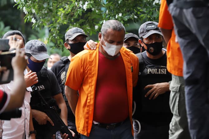 KASUS PENGANIAYAAN: Polisi membawa salah satu tersangka kejahatan John Kei saat rilis di Polda Metro Jaya, Jakarta,  Senin (22/6/2020) kemarin. Tim gabungan Polda Metro Jaya berhasil menangkap 30 orang yakni John Kei beserta anggota kelompoknya dalam kasu