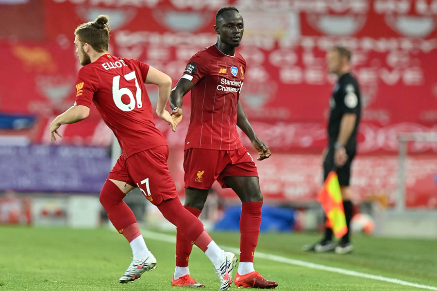 EPL : Sadio Mane (C) dan Harvey Elliott saat pertukaran pemain dalam laga English Premier League berhadapan dengan Crystal Palace di Anfield, Liverpool. (24/6).  Paul ELLIS / POOL / AFP