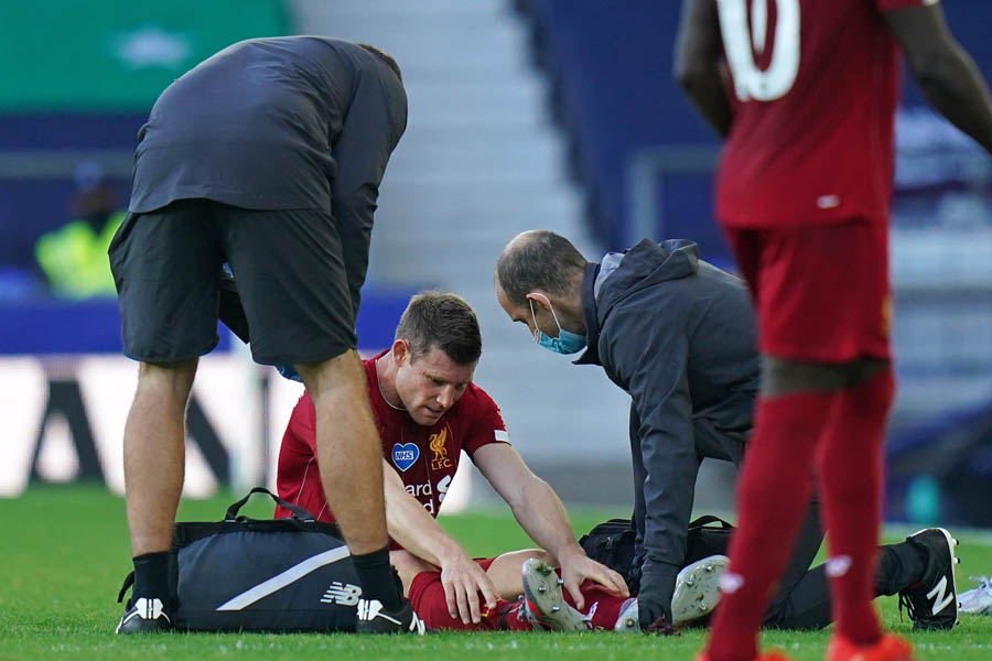 PERAWATAN :  Liverpool James Milner (tengah) mendapat perawatan saat laga melawan Everton di Goodison Park, Liverpool, (21/6).   Jon Super / POOL / AFP