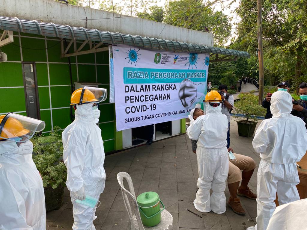 RAZIA MASKER: Petugas sedang mengambil swab dari salah seorang warga yang terjaring razia masker oleh Dinas Kesehatan Kalbar di Taman Digulis Untan, Minggu (12/7) pagi.  DINKES KALBAR FOR PONTIANAK POST