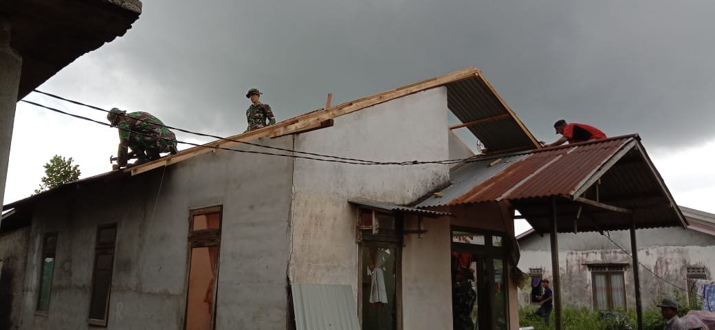 PERBAIKI ATAP: Sejumlah personel Kodim 1207/BS terlihat sedang bekerja memperbaiki atap rumah warga yang rusak akibat puting beliung, kemarin. ISTIMEWA