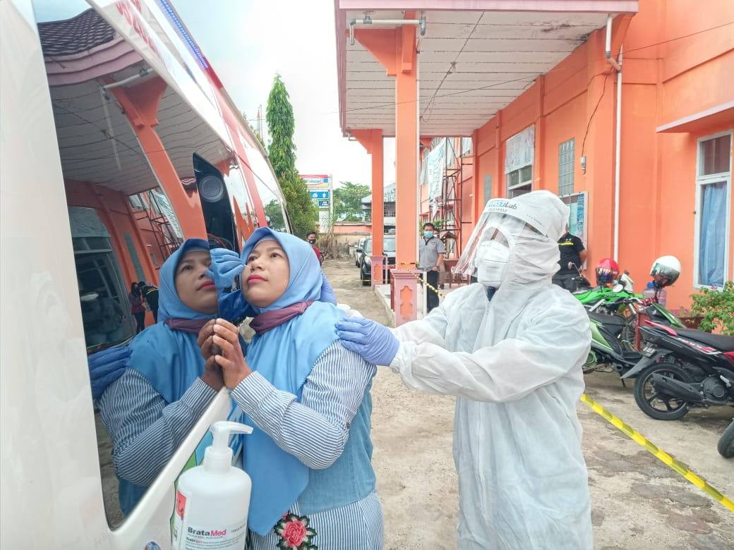AMBIL SAMPEL: Salah satu guru di SMAN 1 Sintang tengah diambil sampel swab-nya untuk diuji di mobil Combat PCR Covid-19. Tes ini berlangsung di halaman sekolah, Selasa (28/7). FIRDAUS DARKATNI/PONTIANAK POST