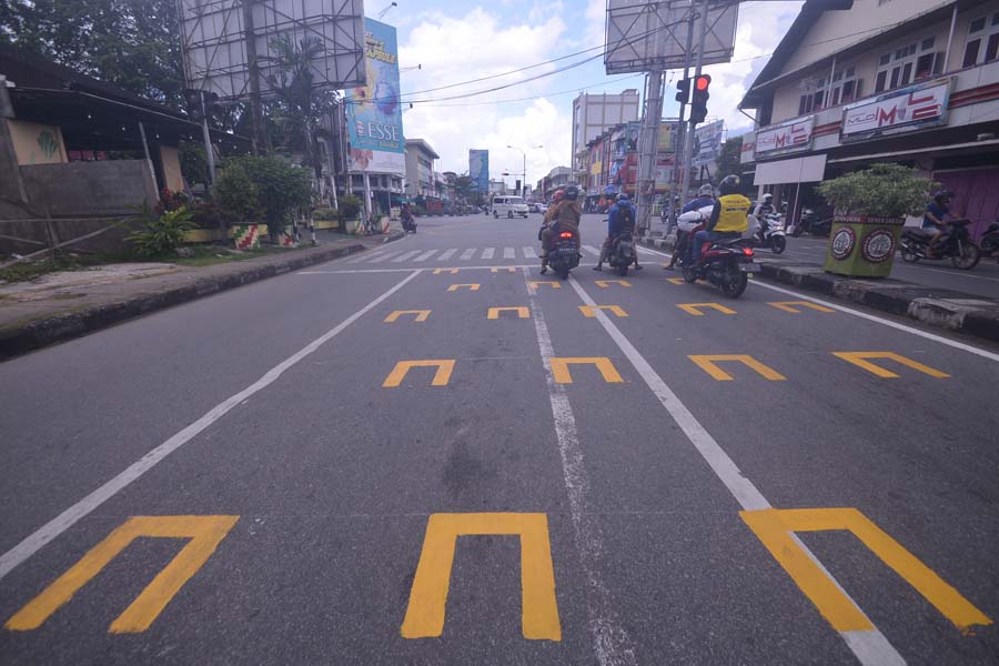 MARKA BARU : Marka ruang henti khusus (RHK) bagi para pengendara sepeda motor mulai diterapkan di Kota Pontianak salah satunya di simpang Jalan Pattimura menuju Jalan Gajahmada, Selasa (21/7). Pembuatan marka RHK ini untuk menerapkan social distancing ant