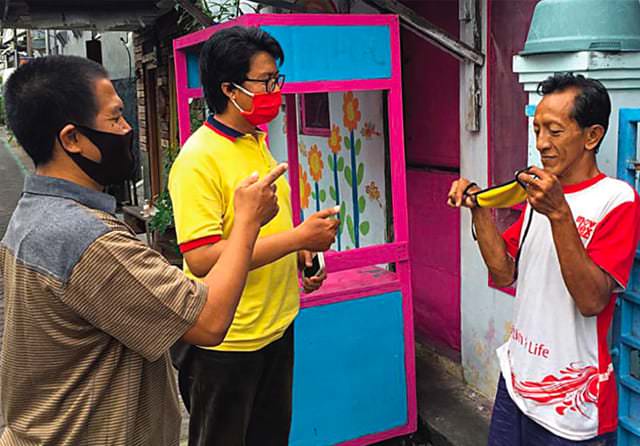 SOSIALISASI: Zainuddin (dua dari kiri) didampingi Wakil Ketua RT 2, RW 3, Helmi Kurnia mengingatkan warga akan pentingnya menggunakan masker ketika keluar rumah.  ADI WIJAYA/JAWA POS