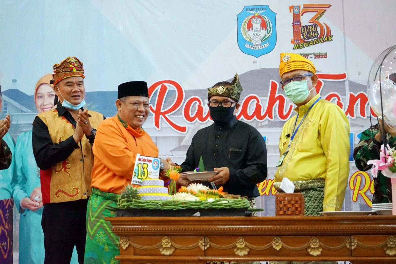 PENYERAHAN TUMPENG: Bupati Kubu Raya, Muda Mahendrawan menyerahkan potongan tumpeng pertama kepada Wakil Bupati Kubu Raya, Sujiwo dalam ramah tamah puncak peringatan HUT ke-13 Kubu Raya.