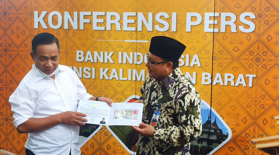 PERKENALKAN: Kepala KPw BI Kalbar Ahus Chusaini menyerahkan secara simbolis uang pecahan Rp75.000 kepada Ketua PWI Kalbar Gusti Yusri.  Aristono/Pontianak Post