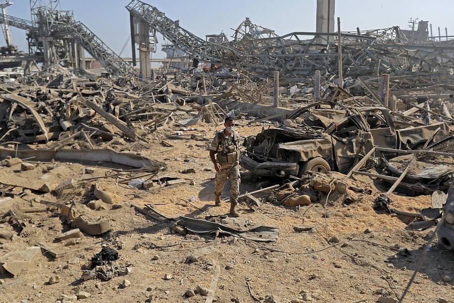 A Lebanese army soldier walks amidst the debris at Beirut port on August 7, 2020, three days after a massive blast there shook the Lebanese capital. - The explosion of a huge pile of ammonium nitrate that had languished for years in a port warehouse serve