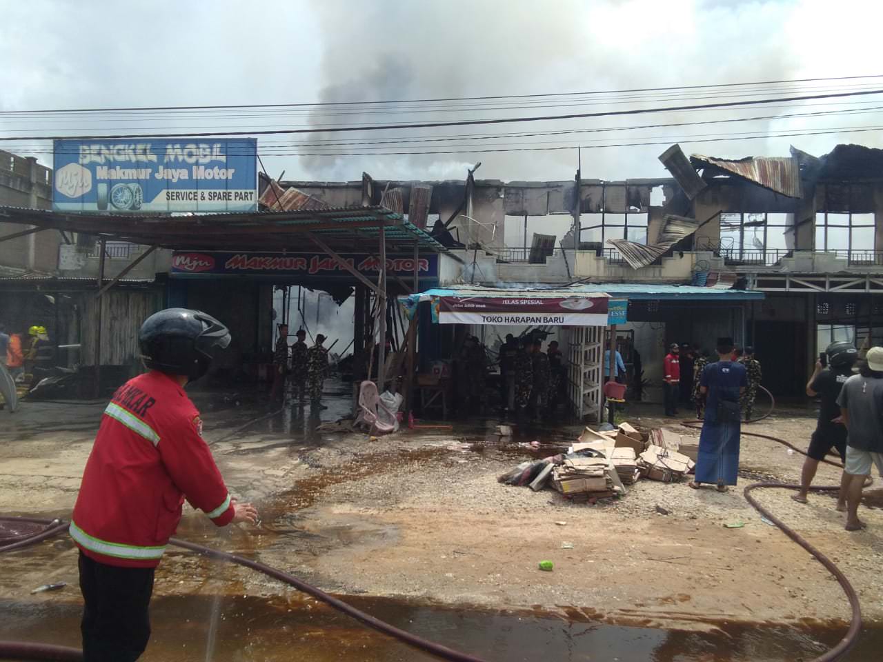 KEBAKARAN: Pihak Damkar dan Busera Sintang tengah melakukan pendinginan pada lokasi kebakaran yang melanda sejumlah ruko di Simpang Pinoh, Kecamatan Sungai Tebelian.  FOTO ISTIMEWA