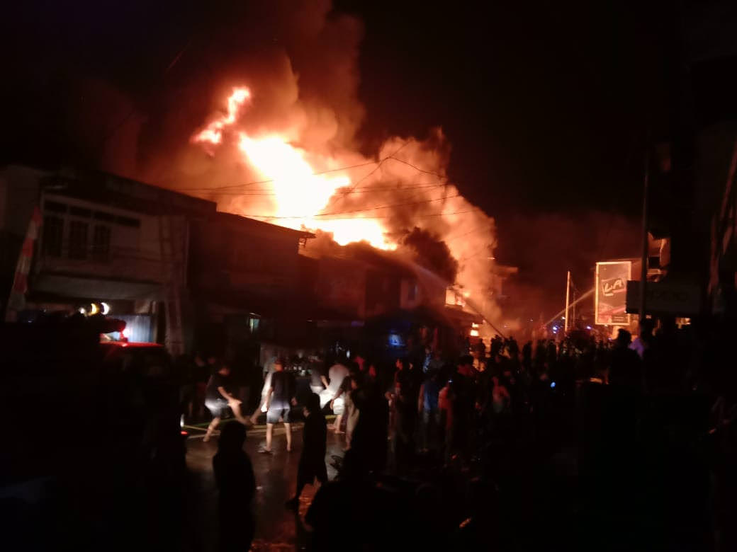 TERBAKAR : Warga bahu membahu memadamkan api yang menghanguskan ruko di Pasar Sandai pada Rabu (9/9) malam. ISTIMEWA