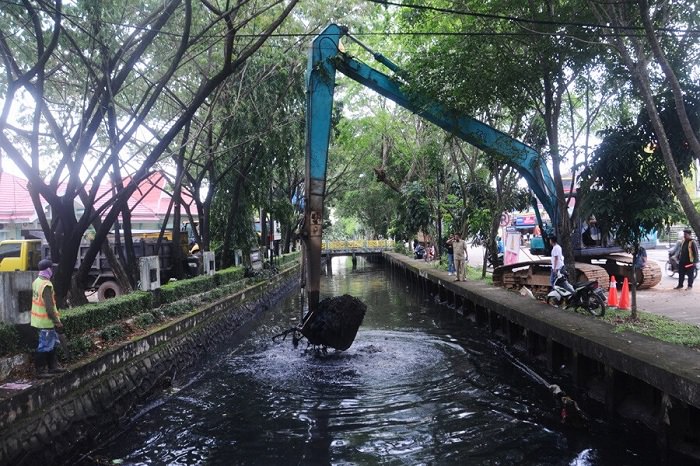ANGKAT LUMPUR: Dinas PUPR Kota Pontianak menggunakan alat berat mengangkat lumpur di Parit Sungai Bangkong, Jalan Alianyang, Kecamatan Pontianak Kota, beberapa waktu lalu. DOKUMEN