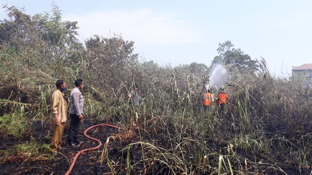 MEMADAMKAN: petugas memadamkan api di lahan kosong dekat Kantor Lurah Sui Pinyuh.WAHYU/PONTIANAKPOST