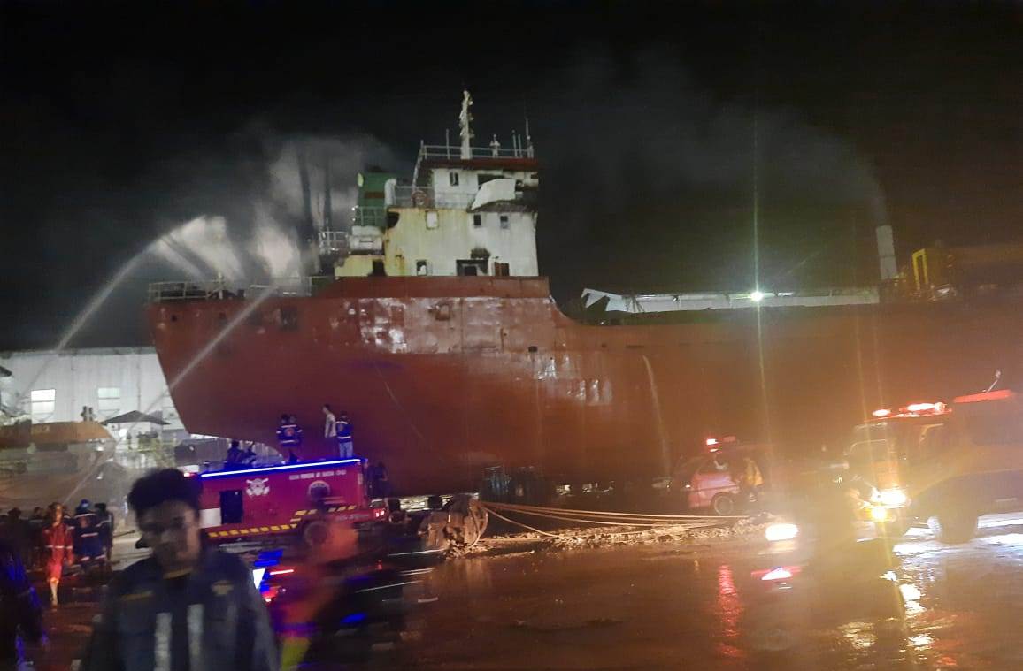 KEBAKARAN: Pemadam kebakaran menyemprotkan air ke badan kapal.ISTIMEWA