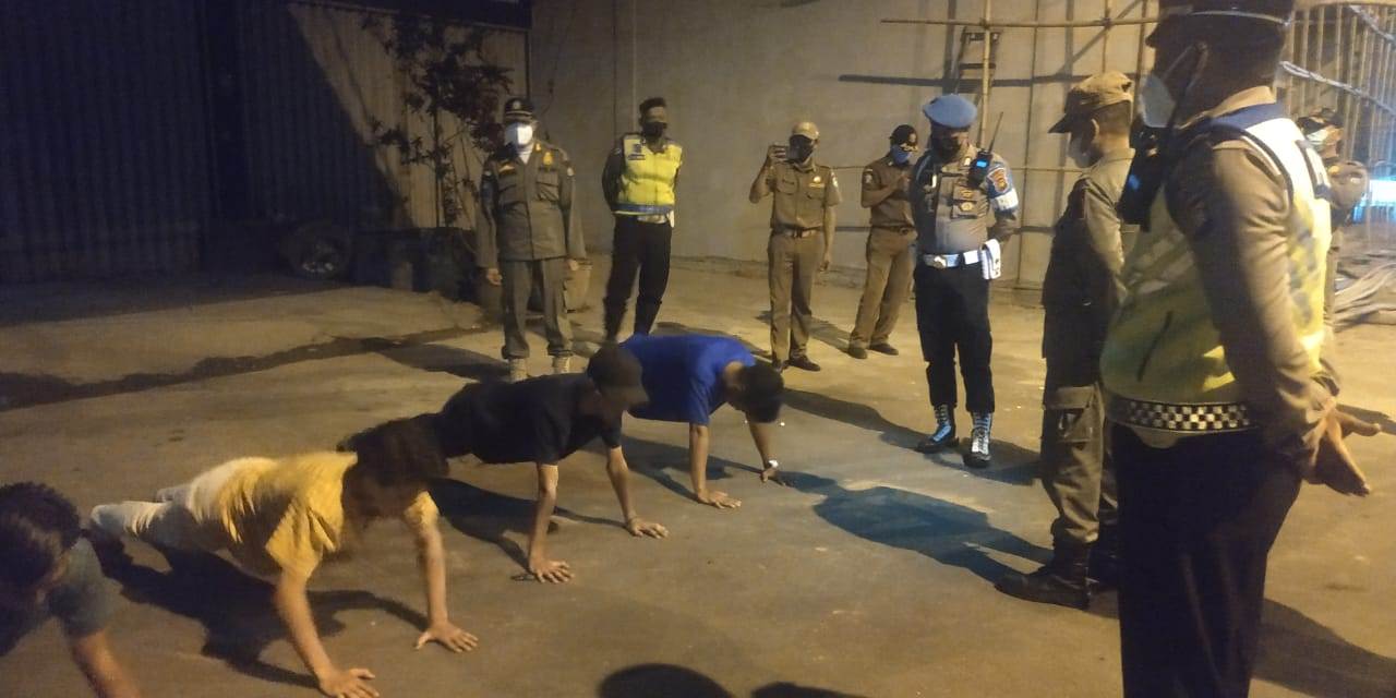 PUSH UP : Sekolompok remaja yang tidak menggunakan masker sedang nongkrong di Jalan Ahmad Yani 2 mendapat sanksi push up oleh petugas operasi gabungan penertiban PPKM Mikro, Sabtu (24/4) malam. SATPOL PP KALBAR