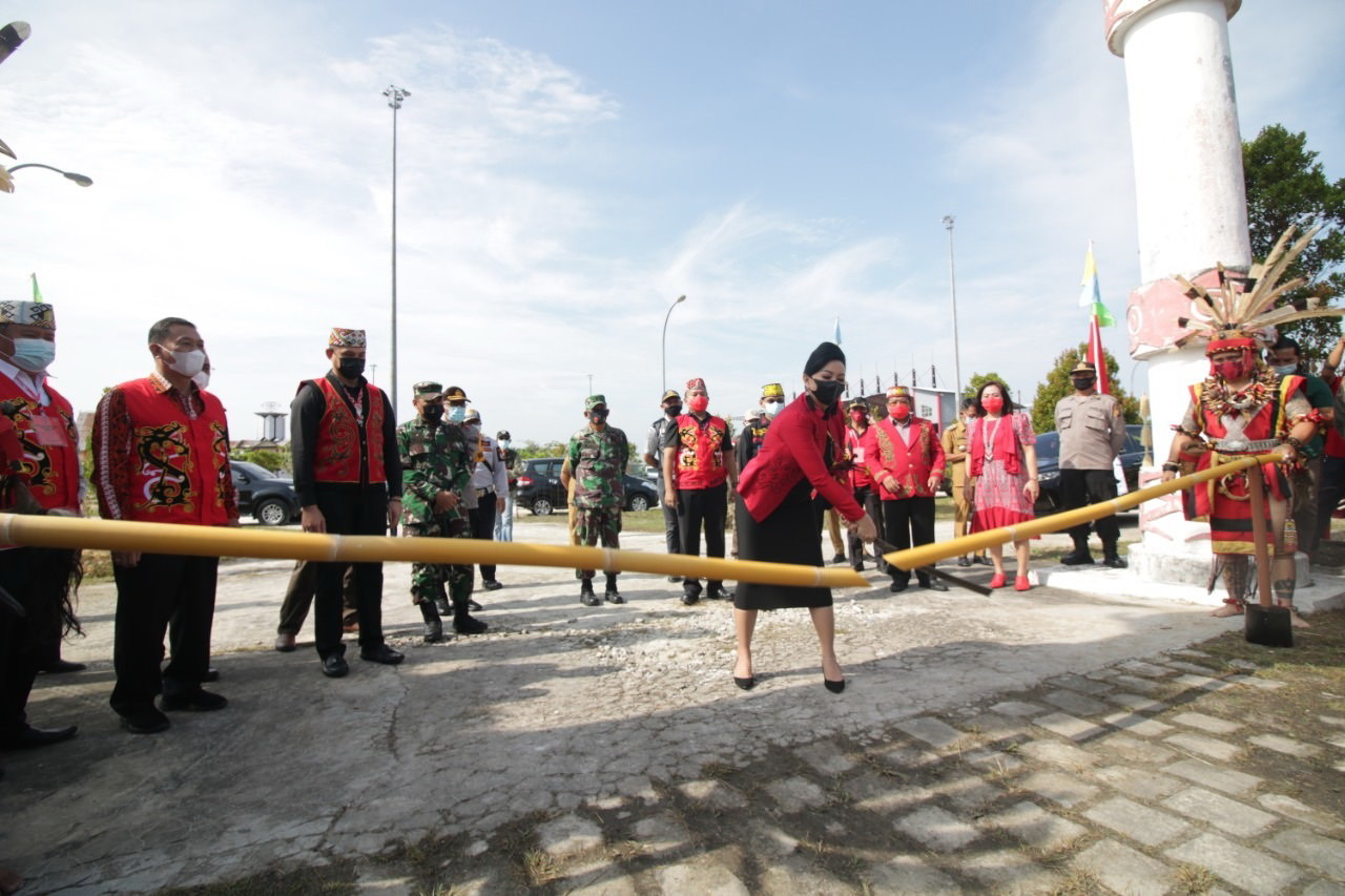 TEBAS PENGHALANG: Bupati Landak Karolin Margret Natasa menebas bambu penghalang saat memasuki areal ritual Adat Naik Dango ke-36 di Rumah Radakng Aya