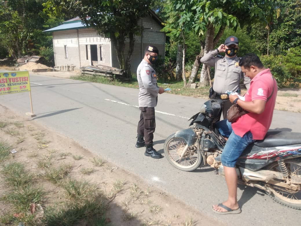 BAGIKAN MASKER: Polisi membagikan masker kepada pengendara sepeda yang melintas di Menyuke, Senin (19/4). ISTIMEWA
