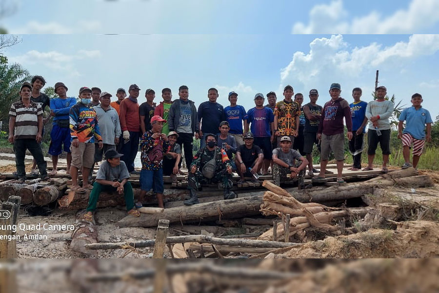 PERBAIKI JEMBATAN - Warga Desa Goa Boma bersama Babinsa Koramil 1202-06/Samalantan saat gotong royong memperbaiki jembatam penghubung yang rusak. ISTIMEWA