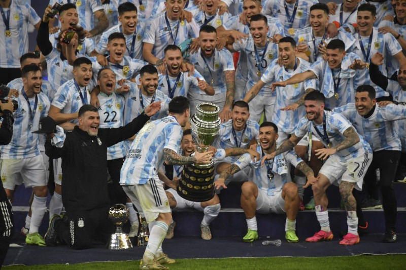 Angkat trofi : Lionel Messi mengangkat trofi di depan rekan-rekan satu timnya ketika mereka merayakan di podium setelah memenangkan final Copa America 2021 melawan Brazil di Stadion Maracana di Rio de Janeiro, Brazil, Minggu (11/7). (Photo by NELSON ALMEI