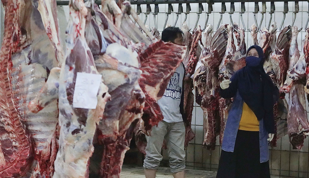 HINDARI KERUMUNAN: Pekerja mengecek daging sapi kurban di Rumah Pemotongan Hewan (RPH) pada perayaan Iduladha tahun lalu. Daging kurban harus diantarkan kepada penerimanya dan tidak boleh ada antrean dalam pembagian daging kurban. (Foto: Imam Husein/Jawa