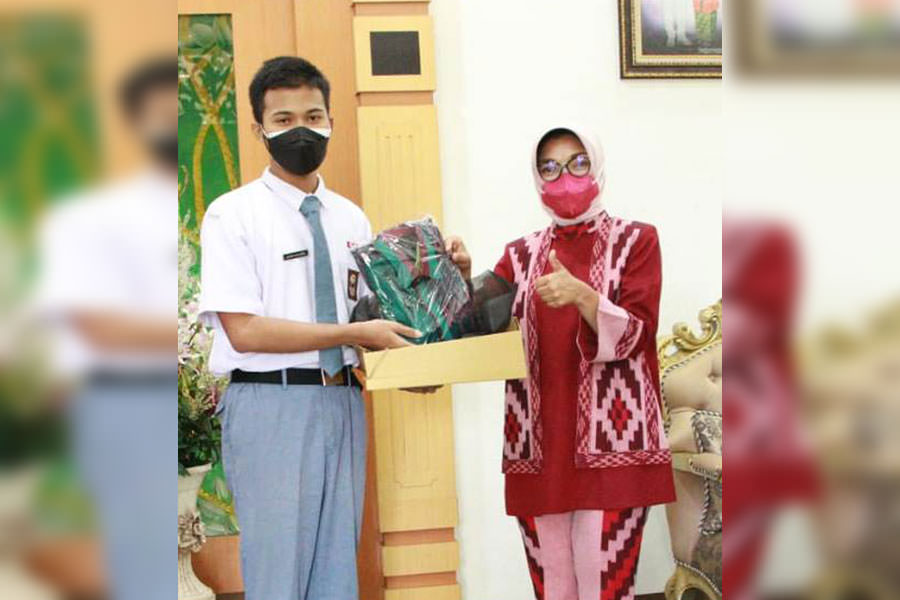 PASKIBRAKA: Ketua Dekranasda Pontianak menyerahkan baju batik corak insang yang di desain khusus Oka Zul, Desainer Dekranasda Kota Pontianak kepada Falih Pangestu. IST