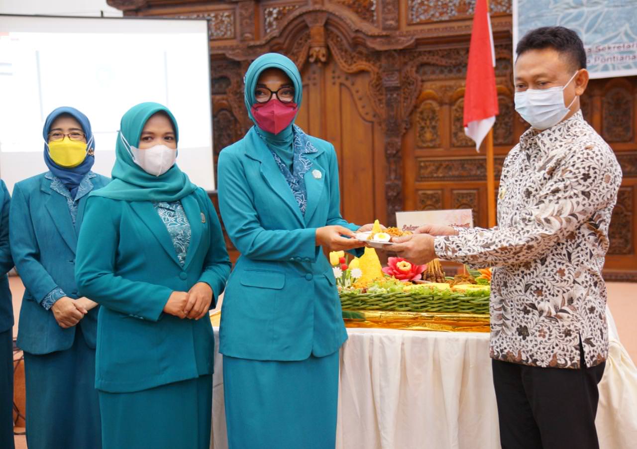 RAKERDA: Ketua TP PKK Kota Pontianak Yanieta Arbiastutie Kamtono menyerahkan potongan nasi tumpeng kepada Wali Kota Pontianak Edi Rusdi Kamtono pada pembukaan Rakerda XI dan HKG PKK ke-49 di Aula Rumah Jabatan Wali Kota Pontianak. Prokopim Pemkot