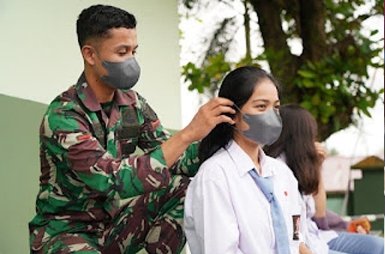PASANGKAN MASKER: Anggota Korem 121 Alambhana Wanawai saat memakaikan masker pada pelajar sebagai edukasi kepatuhan penerapan protokol kesehatan di kehidupan sehari-hari, baru-baru ini.ISTIMEWA