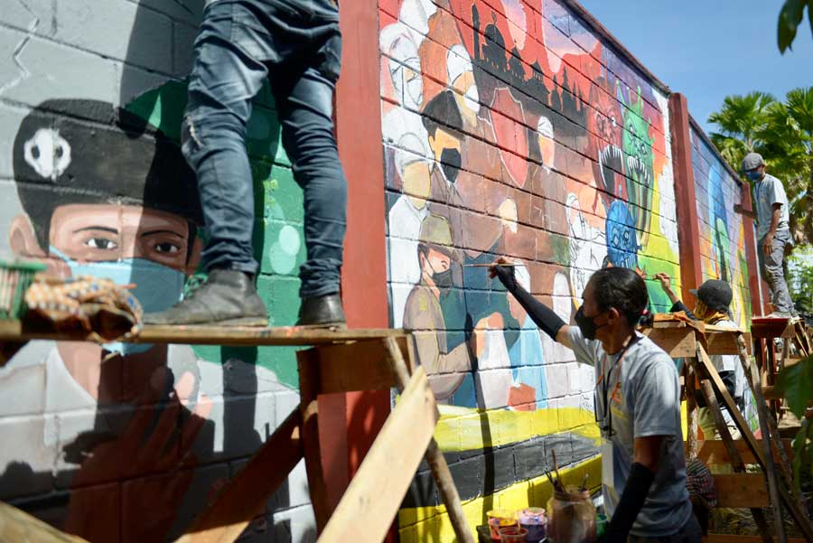 BERKOMPETISI: Seniman mural Kalimantan Barat saat melukis dinding di kawasan Stadion Sultan Syarif Abdurrahman Pontianak, kemarin. ARIEF NUGROHO/PONTIANAK POST
