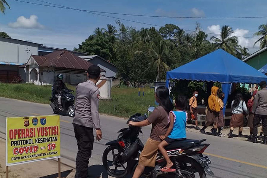 RAZIA: Personel Polsek Mempawah Hulu menggelar Ops Yustisi untuk meningkatkan disiplin Prokes di Desa Karangan, Senin (25/10). ISTIMEWA