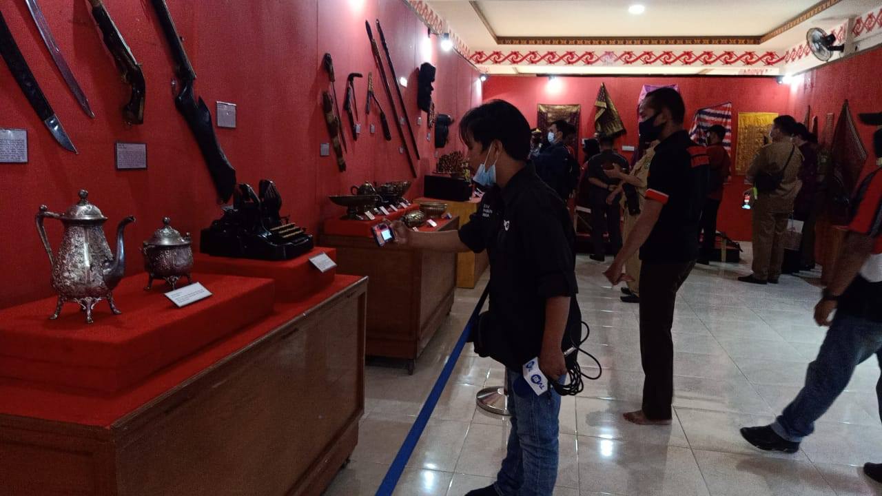 MUSEUM KELILING: Salah satu pengunjung dari kalangan masyarakat saat mengunjungi dan mengabadikan momen benda-benda bersejarah yang disajikan di museum keliling, di Ramin Bantang Bengkayang, Selasa (26/10). SIGIT ADRIYANTO/PONTIANAK POST
