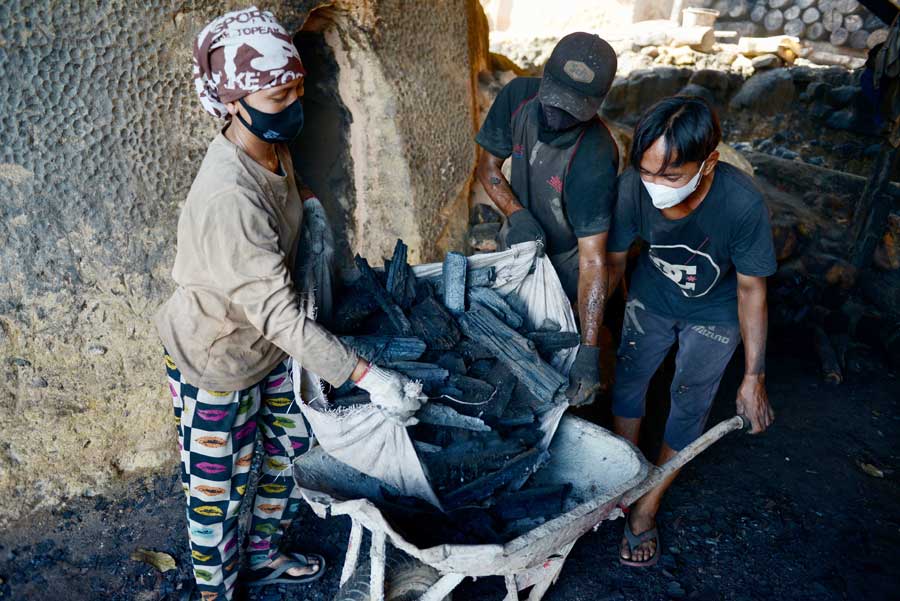 Sejumlah pekerja sedang mengeluarkan kayu arang berbahan pohon bakau dari dapur atau tungku, di Desa Batu Ampar, Kecamatan Batu Ampar, Kubu Raya. Industri arang bakau ini tetap eksis meskipun dianggap illegal karena tidak berizin. (ARIEF NUGROHO/PONTIANAK