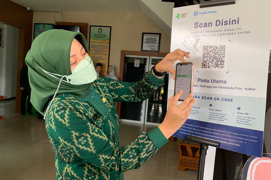 SKRINING : Kepala Disporapar Kalbar Windy Prihastari mendemonstrasikan penggunaan aplikasi PeduliLindungi sebagai skrining penularan Covid-19 di lingkungan Kantor Disporapar Kalbar, Jalan Letjen Sutoyo, Kamis (18/11). SHANDO SAFELA/PONTIANAK POST