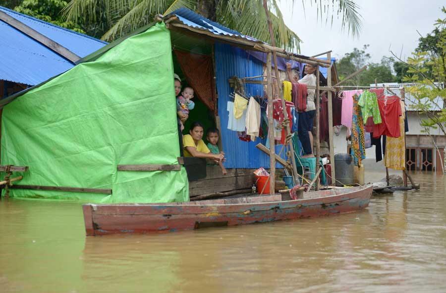 BERTAHAN DI RUMAH: Warga Desa Mungguk Bantok, Kecamatan Sintang bertahan di rumah mereka meskipun banjir telah menenggelamkan sebagian bangunan rumah. ARIEF NUGROHO/PONTIANAK POST  