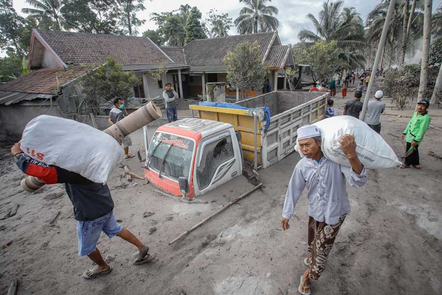 MENGUNGSI: Letusan Gunung Semeru di Kabupaten Lumajang, Jawa Timur memaksa warga mengungsi ke lokasi yang aman. Menurut data BNPB, bencana yang menewaskan 14 warga ini telah merusak sebagian besar rumah warga. DIPTA WAHYU/JAWA POS