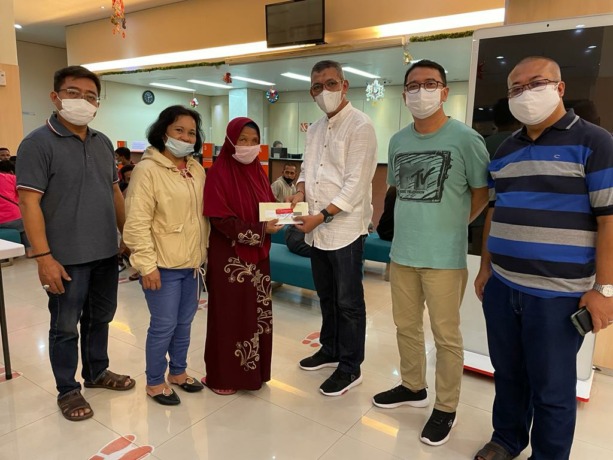 SERAHKAN : Pemimpin BNI KC Pontianak, Mohammad Subairi (tengah), saat menyerahkan kartu untuk Bansos Program Sembako kepada salah seorang penerima manfaat, Sabut (8/1)
