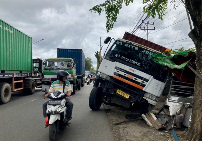 Sebuah truk kontainer menabrak warung di jalan Imam Bonjol, Pontianak Selatan, Kamis (10/2). Truk kontainer tersebut menabrak warung setelah menghindari kendaraan bermotor yang menyalip dari arah berlawanan. foto Arief Nugroho