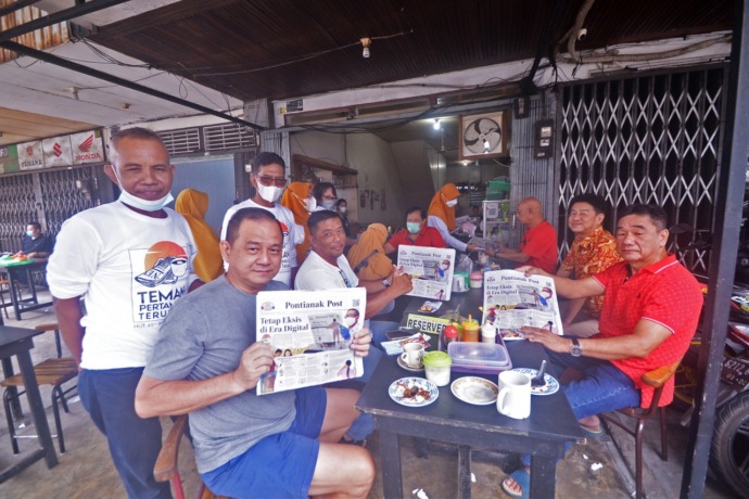 Warga sedang bersantai di warung kopi ditemani koran Pontianak Post. (Meidy Khadafi/Pontianak Post)