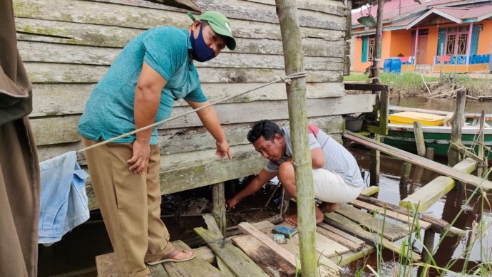 TUNJUKAN LOKASI: Warga menunjukkan lokasi Sudianto diterkam buaya di kampung Api-api Sungai Pinyuh. (Istimewa)