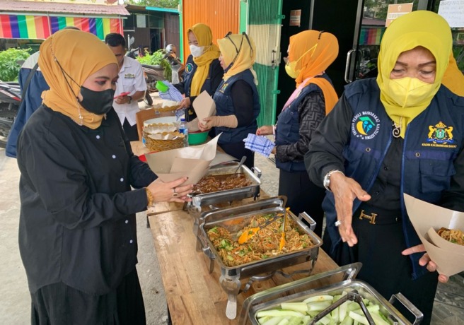 Wina Handayani membungkus nasi untuk masyarakat yang datang di Rumah Makan Gratis Kadin Kalbar di Jalan Perdana. foto Shando Safela