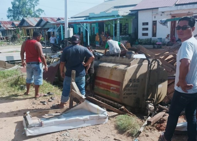 NABRAK KIOS: Truk tangki pengangkut CPO masuk parit usai menabrak kios warga. (IST)