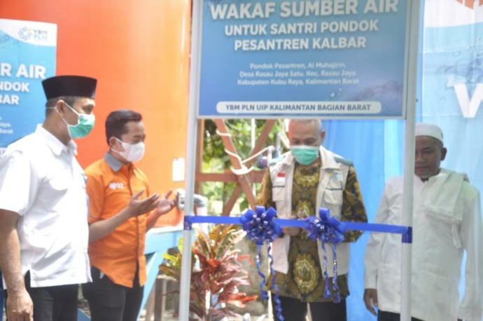 Didik Mardiyanto, General Manager PLN UIP KLB mengunting pita saat menyalurkan program wakaf sumber air untuk Pondok Pesantren Al Muhajirin (PLN). (IST)