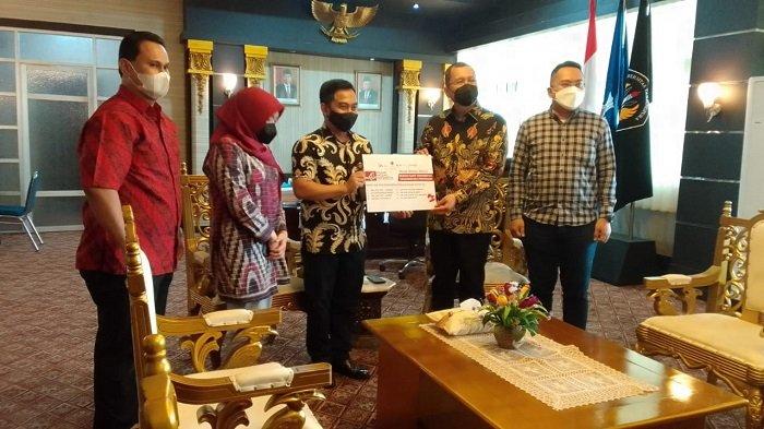 PASAR MODAL: Kepala Kantor Perwakilan BEI Pontianak Taufan Febiola menyerahkan APD bagi RS Untan yang diterima Rektor Untan Prof Dr Garuda Wiko. Istimewa