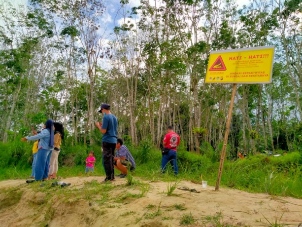 IMBAUAN: Tim Gabungan memasang plang imbauan dan edukasi bahaya buaya di Dusun Tanjung Desa Hilir Tengah Kecamatan Ngabang, Kamis (9/6). (istimewa)