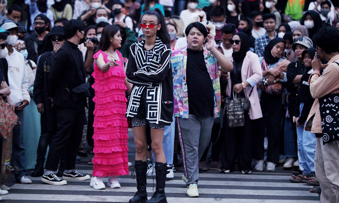 Masyarakat berkumpul saat menyaksikan fashion week di Dukuh Atas, Jakarta, Jumat (22/7/2022). Pemerintah Provinsi DKI Jakarta mengeluarkan aturan tegas dengan menerapkan jam malam di kawasan Stasiun BNI City, Dukuh Atas, Jakarta Pusat. Tempat ini sekarang